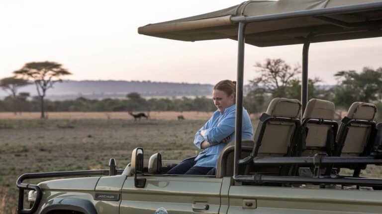 Woman on a safari vehicle with arms folded looking very unhappy