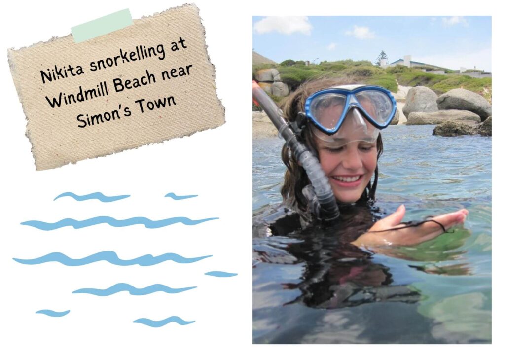 Nikita snorkelling at Windmill Beach - she's in the ocean and holding a brittle star in her hand and her goggles are on her forehead