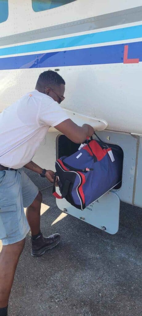 Pilot putting luggage into the hold of a plane