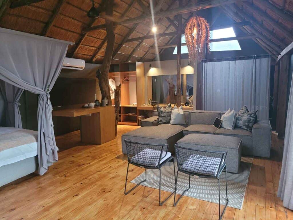 Interior of a tent at Victoria Falls River Lodge showing the beds, the lounge area and the bathroom