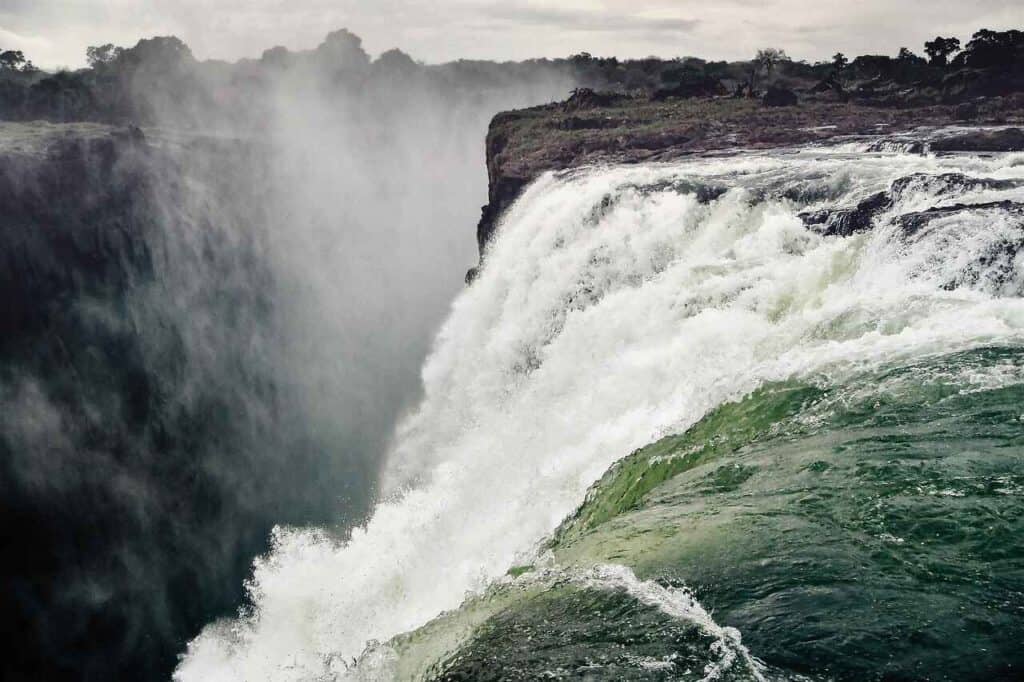 The Zambezi River flows over the edge of the cliff, forming the world-famous Victoria Falls.