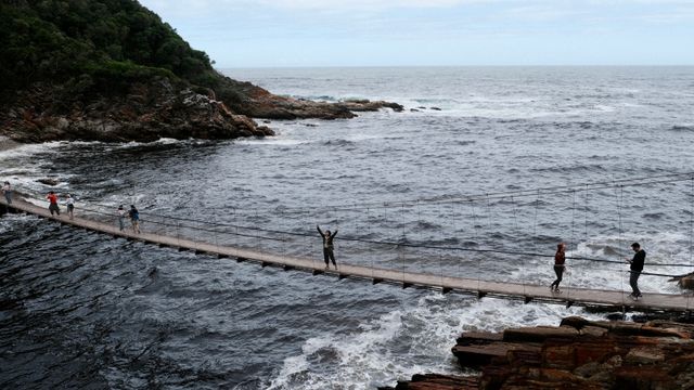 People crosing the Storms River Bridge along the Garden Route